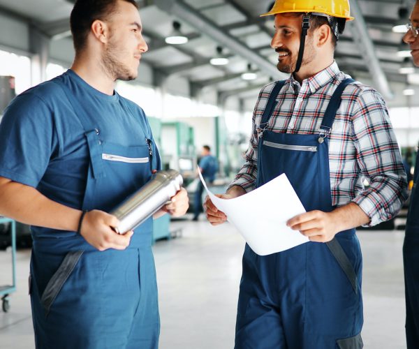 Factory worker discussing data with supervisor in metal factory